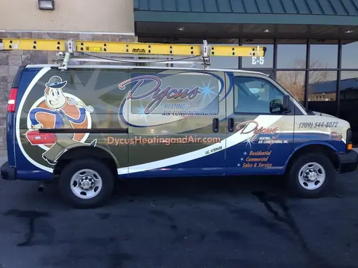 A Dycus Heating and Air Conditioning work van parked outside a commercial building