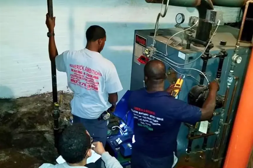 HVAC technicians servicing a boiler in a basement mechanical room