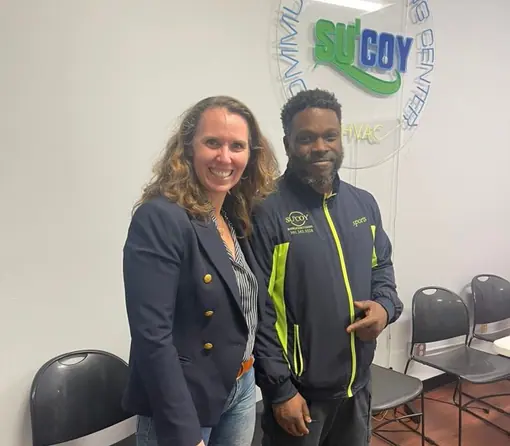 A Su&rsquo;Coy team member standing with a colleague inside the Community Learning Center