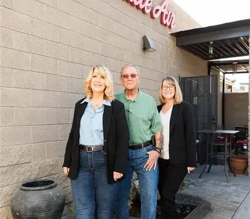 Three members of the Accurate Air team standing outside their building beneath the Accurate Air sign