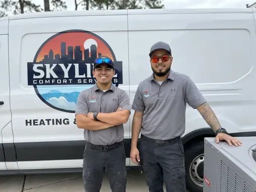 Two Skyline Comfort Services technicians standing in front of their branded service van