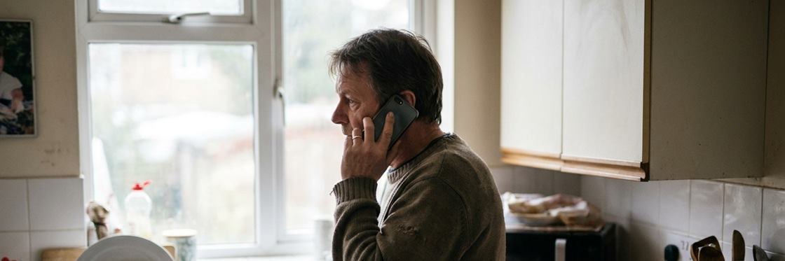 A homeowner on the phone in a domestic kitchen.