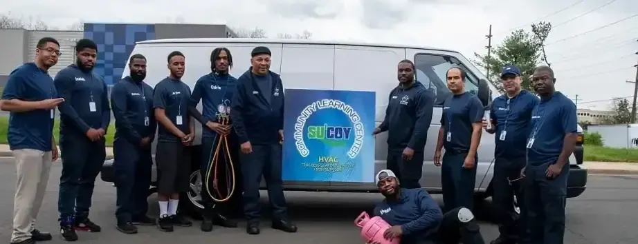The Su&rsquo;Coy team gathered around a service van holding a Community Learning Center sign