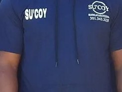 The Su&rsquo;Coy mark embroidered on a crew uniform shirt